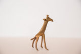 Close-up of the vintage golden bronze giraffe sculpture's textured head and neck.