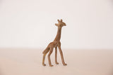 Side view of a small bronze giraffe highlighting its slender form and aged texture.