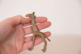 A vintage African bronze giraffe sculpture resting in the palm of a hand.