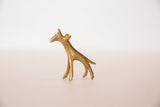 Side profile of a vintage African bronze giraffe with a textured golden hue.