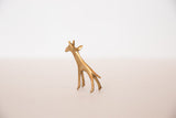 Three-quarter view of a vintage mini bronze giraffe with a golden, textured finish.