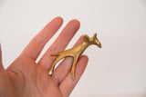 Vintage golden bronze giraffe shown in hand to illustrate its small size.