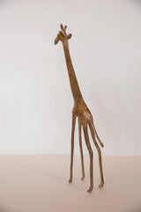 Side view of the vintage bronze giraffe sculpture highlighting its elegant slender profile.