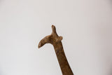 Profile view of a vintage bronze giraffe head highlighting its textured and aged patina.