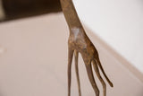 Textured, patinated finish on the slender legs of a vintage bronze giraffe sculpture.