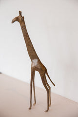 Full side view of a vintage bronze giraffe with a textured, aged finish.