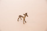 Side profile of a vintage golden bronze gazelle showing its slender, textured body.