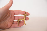 Vintage golden bronze gazelle fawn held in hand to illustrate its small, collectible size.