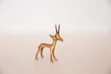 The textured, handmade finish of a vintage golden bronze gazelle sculpture.