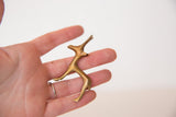 Vintage African golden bronze gazelle sculpture, held in hand, showing its unique texture.