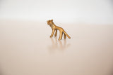Angled view of vintage handmade bronze miniature lion with golden hue.