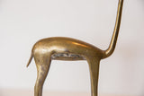Bronze gazelle sculpture with aged patina and darkened texture on its belly.