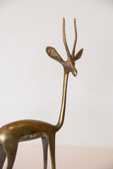 Patinaed bronze gazelle sculpture's head, showing its elegant neck and ridged horns.
