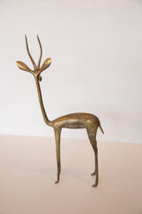 Slender legs and stylized feet of the vintage bronze gazelle sculpture, showing patina.