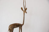 Vintage African bronze gazelle sculpture's textured body and long neck with aged patina.