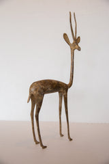 Patinaed bronze texture on the slender legs of the vintage gazelle sculpture.