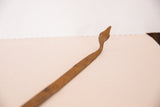 Profile view of the sculpted head of a vintage iron snake showing rustic patina.