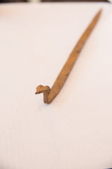 Close-up of vintage African iron snake sculpture's head with rustic brown patina.