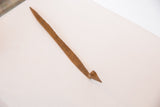 Pointed end of the vintage African iron snake sculpture, showing its rustic brown patina.