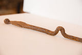 Vintage African iron stake showing its distinctive curved shape and aged, rusted texture.