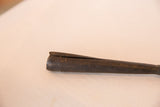 Dark, textured iron and the distinctive split end of the African spear tip.