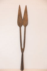 Double-headed spear tip made of dark, rustic iron with aged patina.