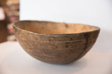Dark brown, textured wood surface and worn rim of a vintage African bowl.