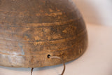 Primitive etched patterns and cord emerging from a hole on the vintage wooden bowl.