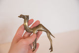Hand holds stylized vintage African bronze camel sculpture with rich, aged patina.