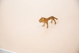 The stylized form and rusty patina of a vintage African mini bronze lion.