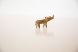 Profile of a small handmade bronze rhino with a rustic, aged patina.