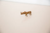 Profile view of a vintage bronze rhino sculpture with a mottled, rustic patina.