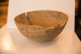 Vintage hand-carved wooden bowl's primitive rim showing irregular edges and large split.