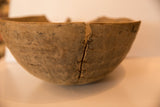 Primitive African wooden bowl's aged, textured surface with natural imperfections.