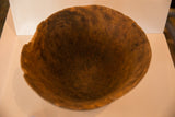 The deep, hand-carved interior of a vintage African bowl showing a rustic finish.