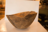 Primitive African wooden bowl exterior with hand-carved lines and aged texture.