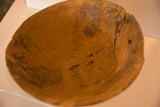 Close-up of vintage African wooden bowl interior, showing deep cracks and primitive texture.