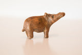 Vintage copper hippopotamus casting turning to its side with aged patina.