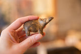Side profile of the collectible bronze hippo showing its charming upward pose and patina.