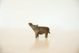 Side view of the small bronze hippo showing its upward-turned head and aged finish.