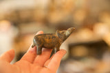 Small vintage bronze hippo sculpture held in hand to show its scale and aged patina.