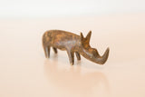 Vintage African bronze rhino figurine in profile, showing its slender form and aged texture.