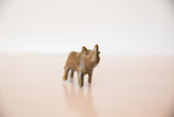 Front view of a turning bronze rhino sculpture showing its aged, handmade patina.