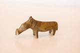 Side view of a vintage bronze hippo sculpture highlighting its skinny form and aged patina.