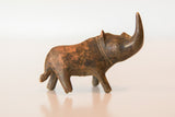 Vintage copper rhinoceros head close-up, showing upward-curved horn and rich, textured patina.