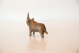 Vintage dark copper rhinoceros sculpture, rear view, showing aged patina.