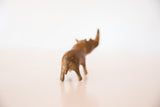 Vintage bronze rhinoceros figurine, showing its textured rear and tail.