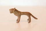 Profile view of a vintage mini copper lion showing its simple form and aged, textured patina.