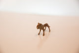 The walking pose of a vintage African mini copper lion figurine.
