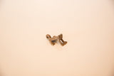 Side profile of a cast copper frog pendant showing its arched back and hanging loop.